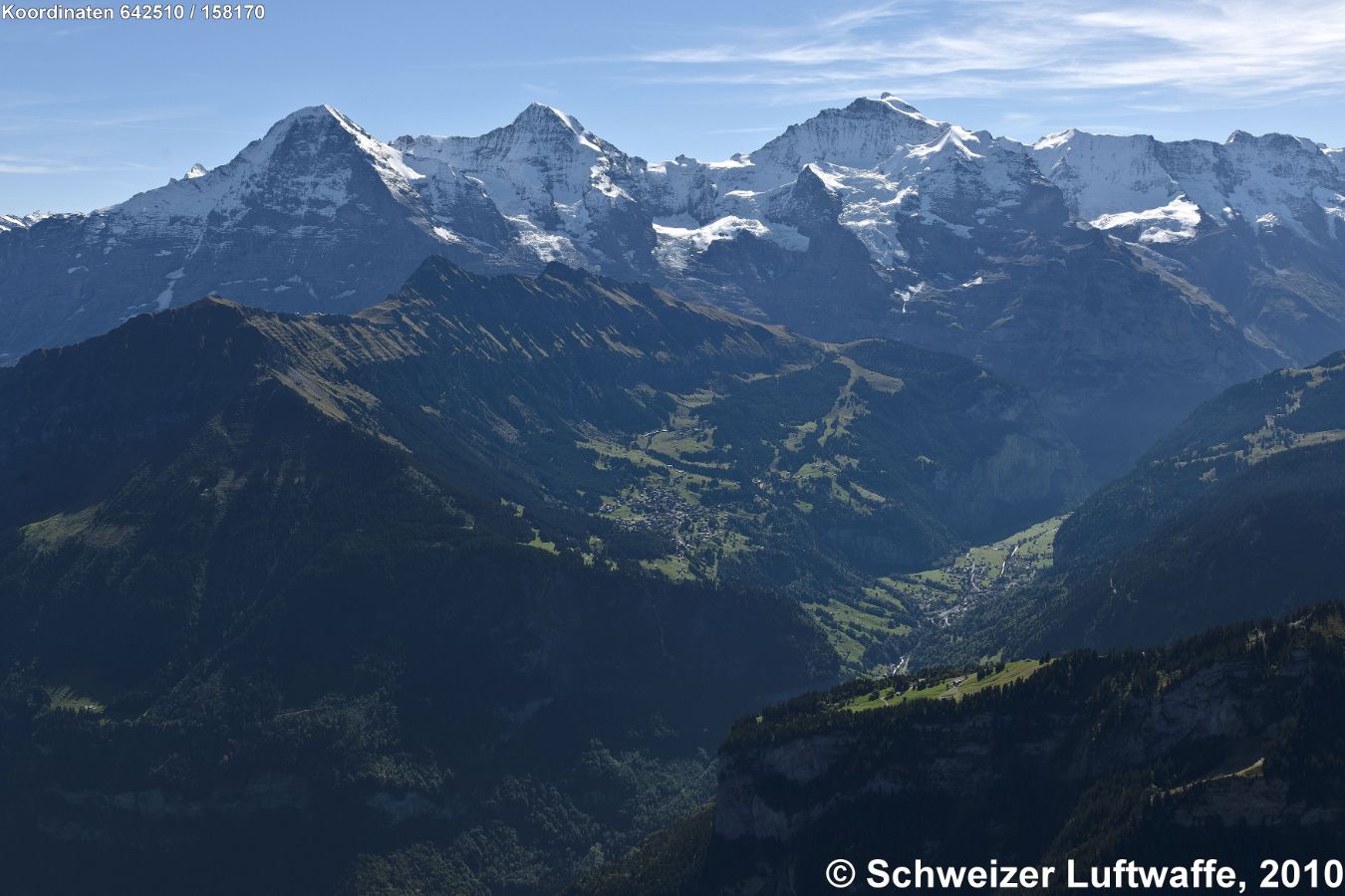 Eiger- Mönch - Jungfrau; zwischen Mönch und Jungfrau: Sphinx/Jungfraujoch. Vorgelagert zur Jungfrau in der Bildmitte: Wengen und Wengeneralp, im Tal unten: Lauterbrunnen. (Norden: untere linke Bildecke)